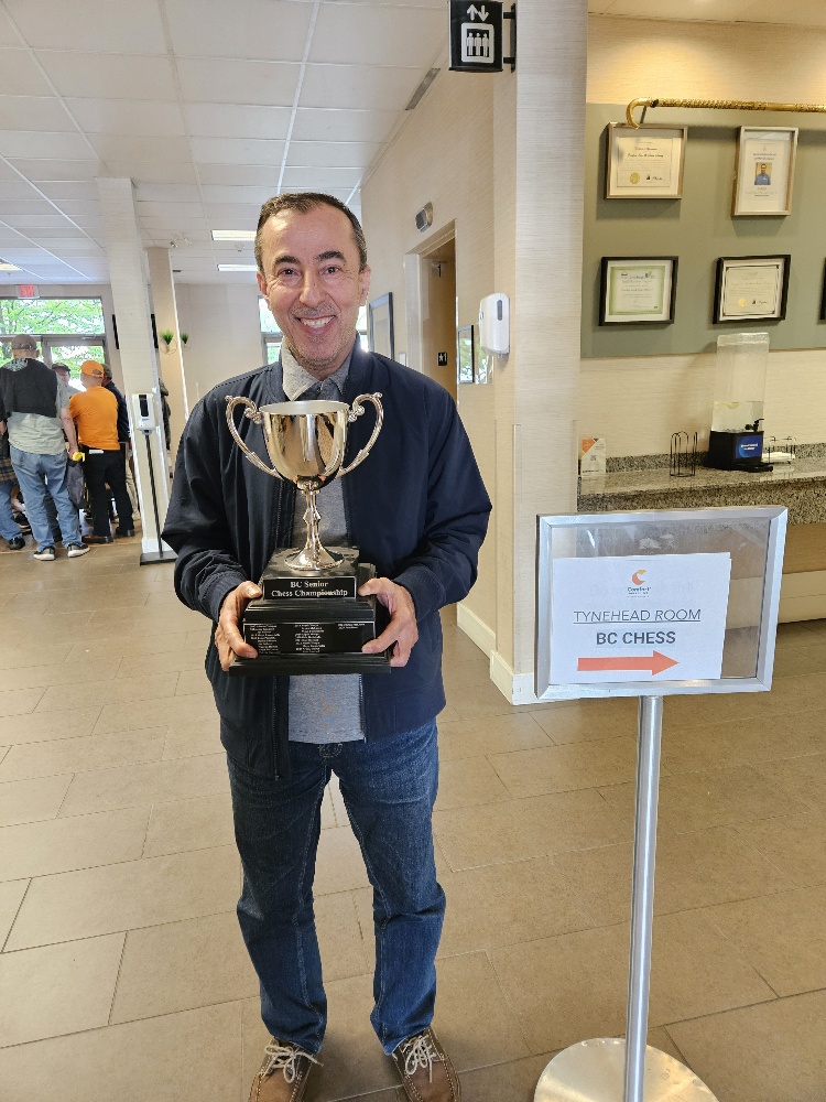 Arpak Qanee holding the BC Chess Championship trophy
